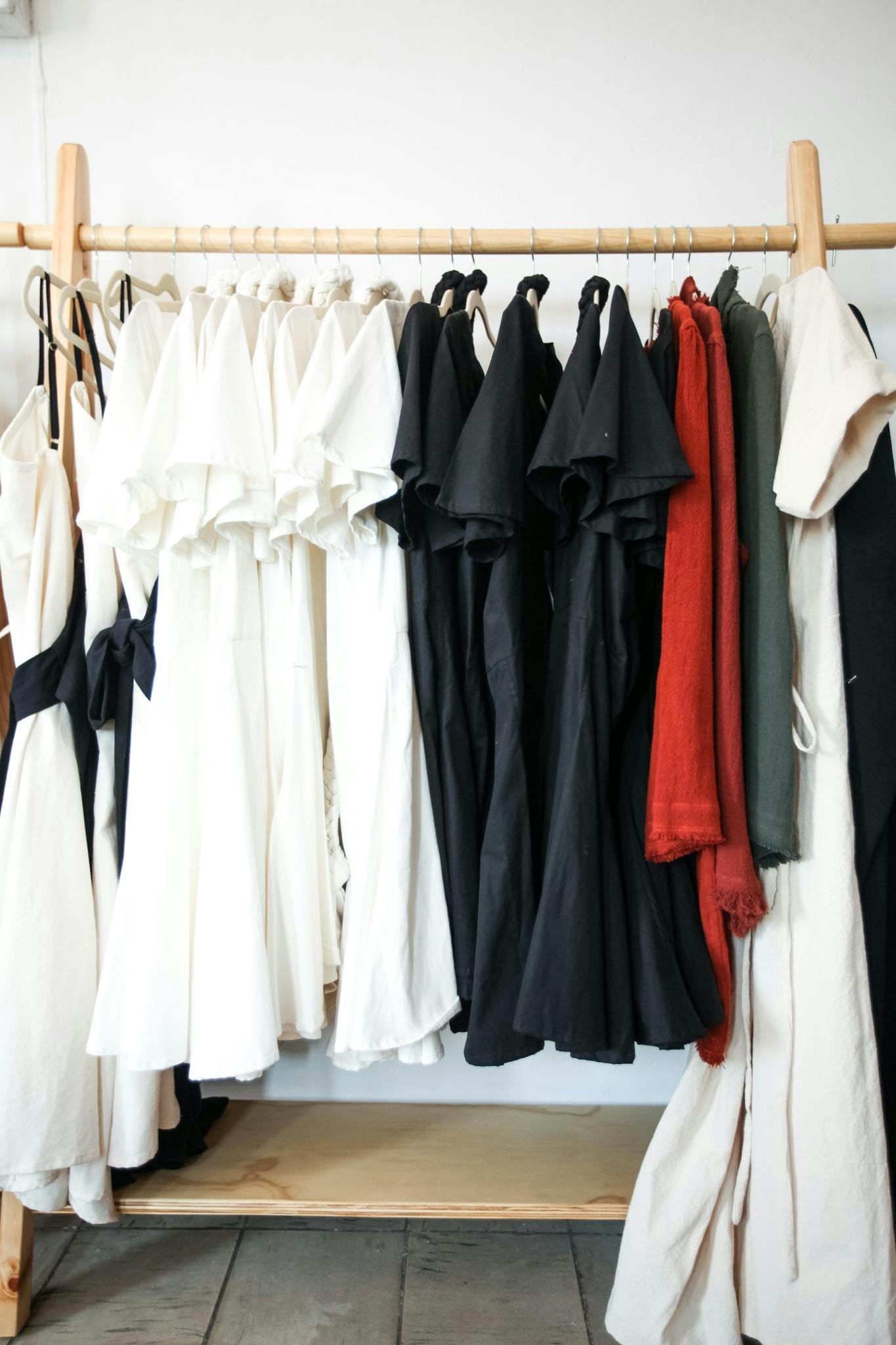 A stylish display of black, white, and red dresses hanging in a boutique, showcasing contemporary fashion.
